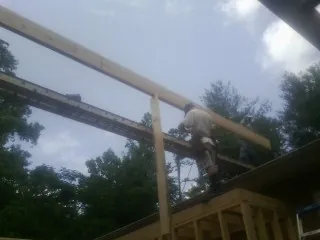 Carpenter setting a ridge beam over a new addition frame — Ice Dam Removal by Roofing Brothers in Shreveport