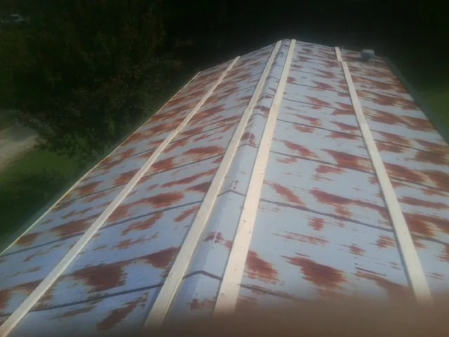 Rusted metal roof panels with new wood purlins before replacement — Storm Damage Roof Repair in Shreveport by Roofing Brothers