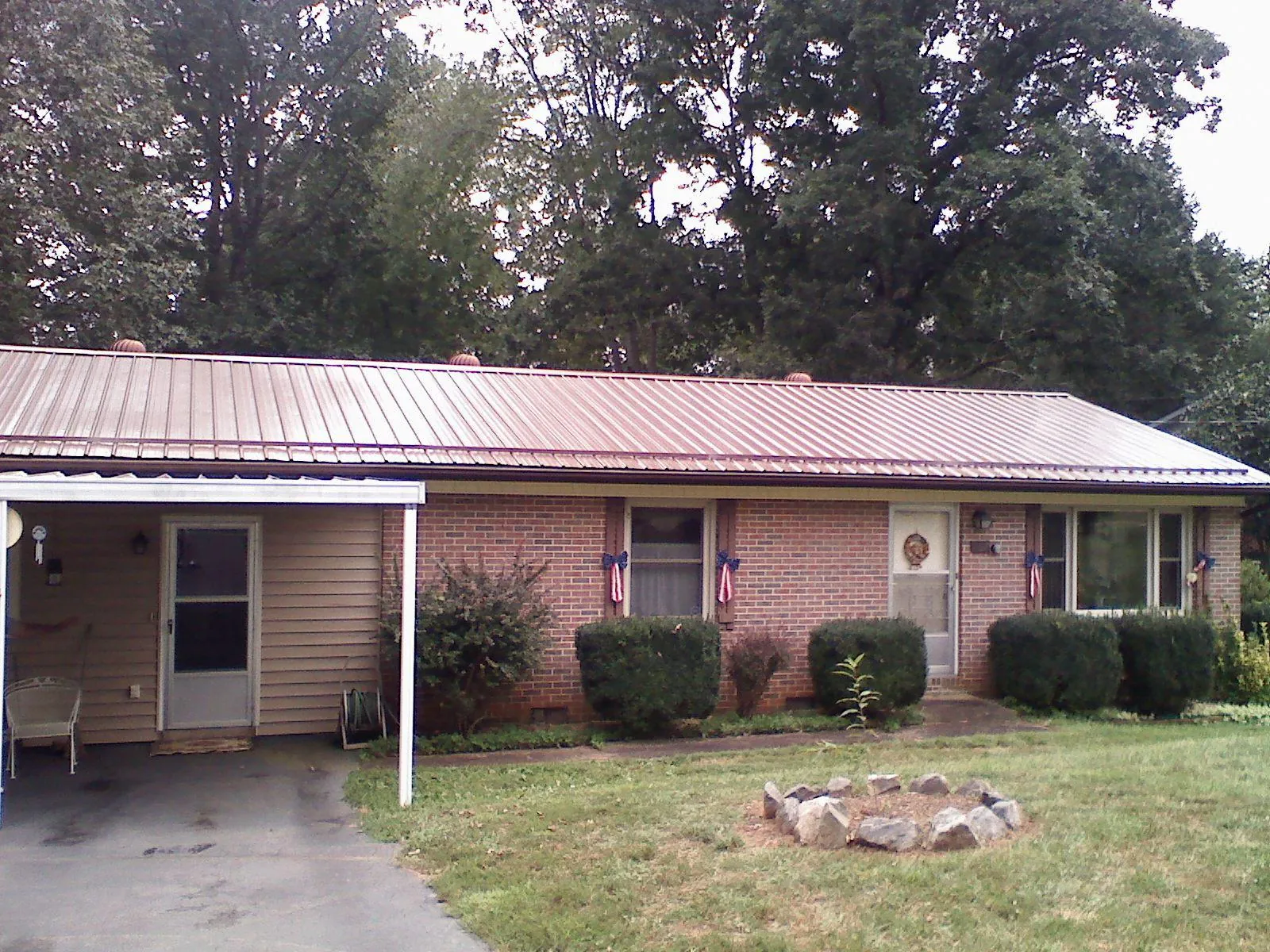 Bronze metal roof and carport on a brick ranch home — Roof Repair work by our crew in Shreveport