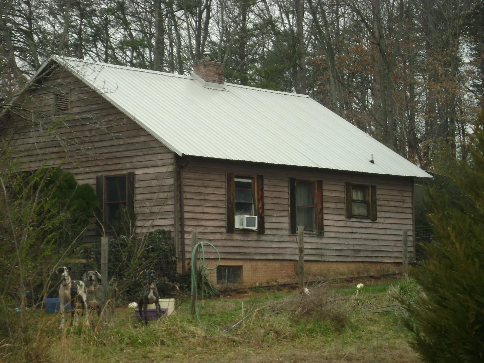 White metal roof on an old wood sided farmhouse, from a Metal Roof Installation job in Shreveport